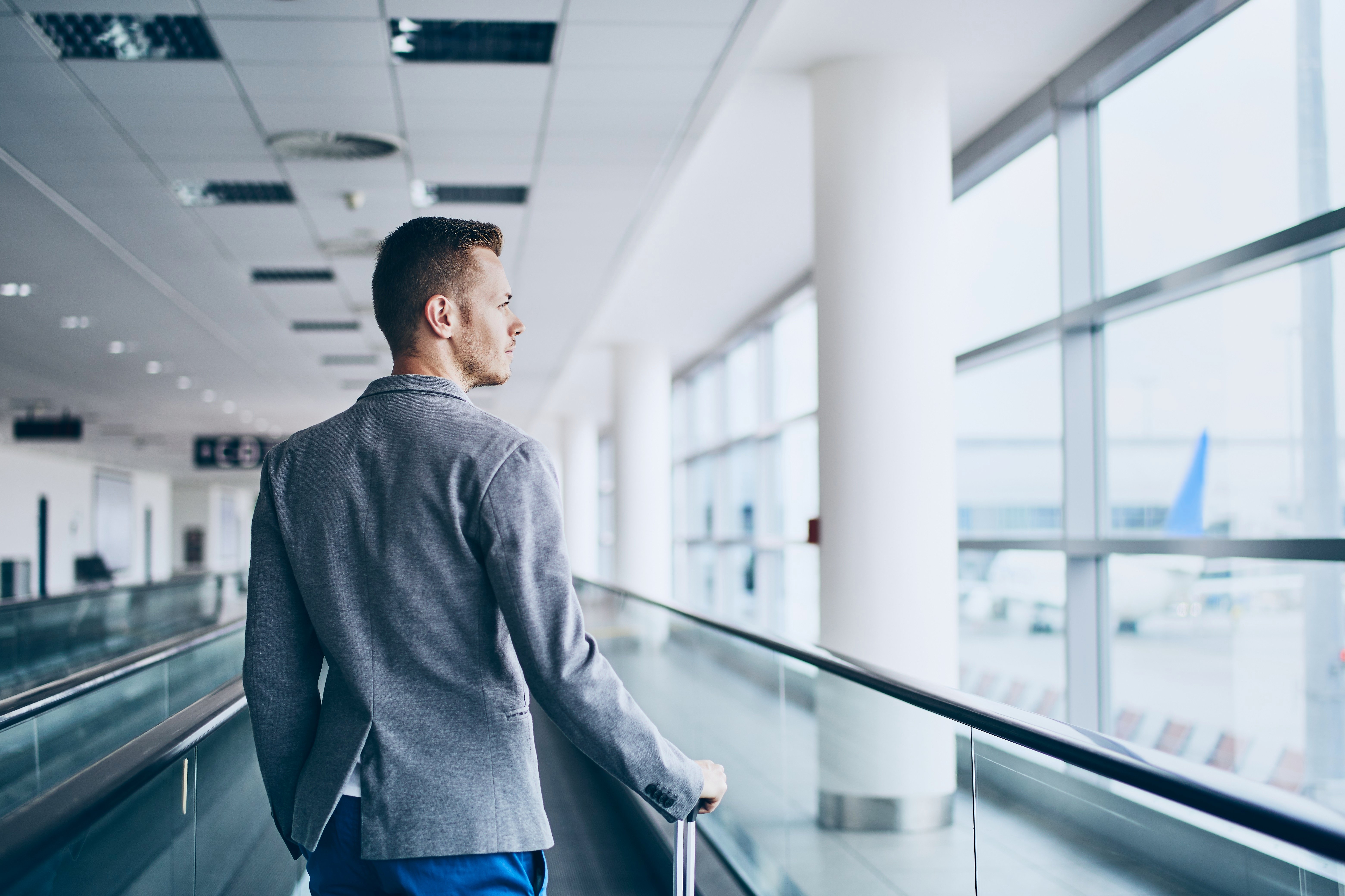 well-dressed-young-man-travel-by-airplane-8YL92R7